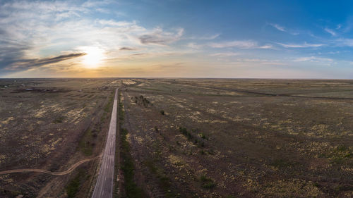 Scenic view of land road against sky during sunset