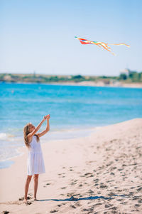 Woman standing on beach against sky