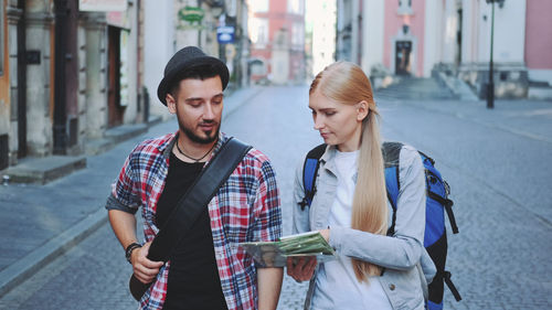 Young couple standing on street in city