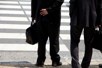 Low section of business people with luggage on road
