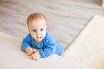 Portrait of cute boy lying on floor at home