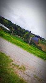 Scenic view of field against cloudy sky