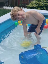 Shirtless boy in wading pool