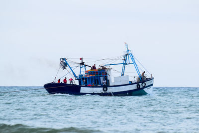 Boat sailing in sea against clear sky