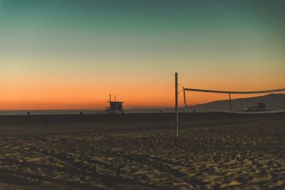 Scenic view of beach against clear sky during sunset