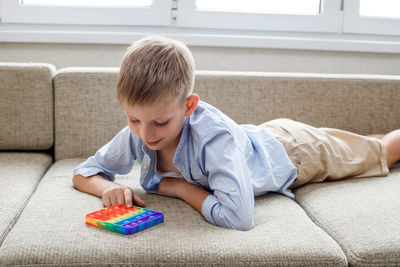 Boy lying on sofa at home