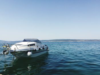 Boats in sea against clear sky