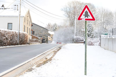 Road sign by snow in city