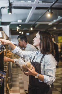 Sales clerks arranging food packets on shelves in grocery store