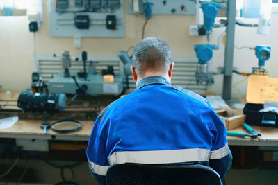 Rear view of man working on table