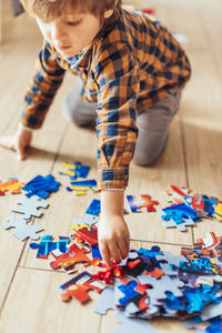 High angle view of boy playing with toy on floor