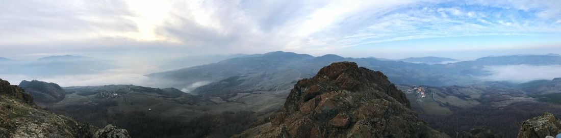 Panoramic view of mountains against cloudy sky