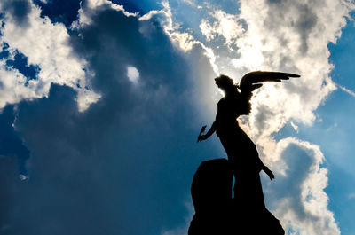 Low angle view of silhouette statue against sky