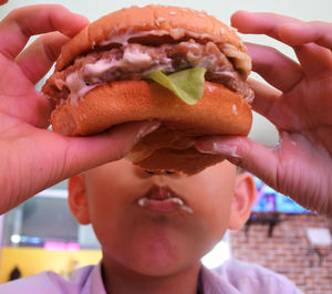 Close-up of boy eating burger in restaurant
