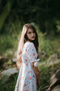 Side view portrait of young woman standing in forest