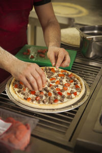 Midsection of man preparing food in kitchen