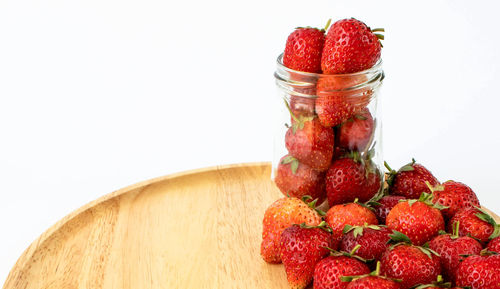 Close-up of strawberries on table against white background