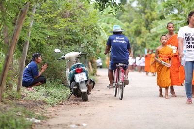 Rear view of people walking on road