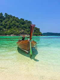 Sailboat in sea against clear blue sky