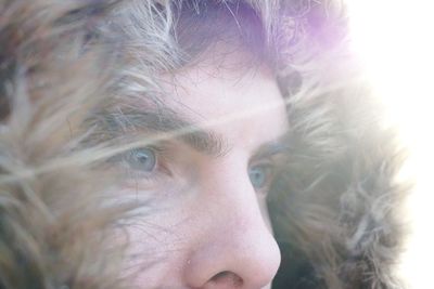 Close-up of thoughtful man in fur hood during sunny day