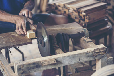 Midsection of carpenter working in workshop