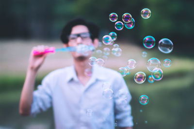 Full length of young man in bubbles