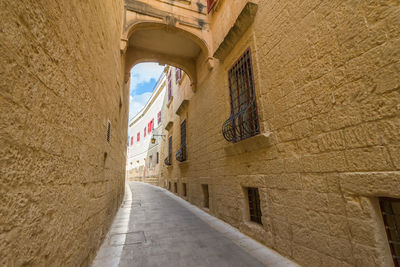 Alley amidst buildings in city, mdina, malta