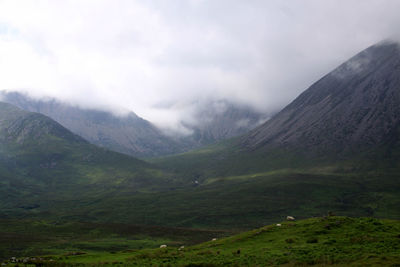 Scenic view of mountains against cloudy sky