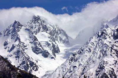 Low angle view of snowcapped mountains against sky