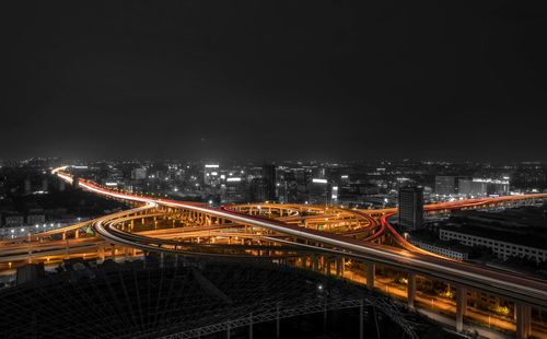 Illuminated suspension bridge in city against sky at night