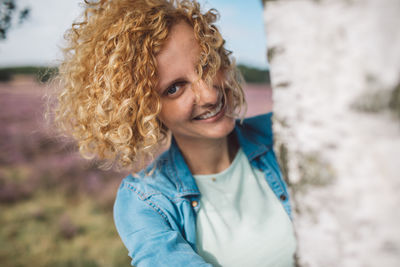 Portrait of young woman standing against wall