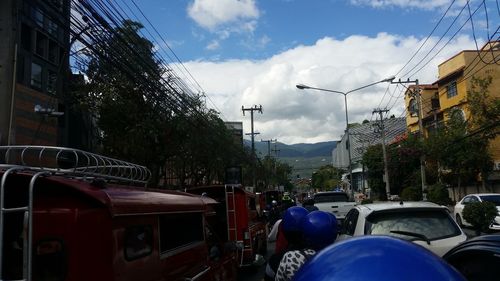 Cars on road in city against sky