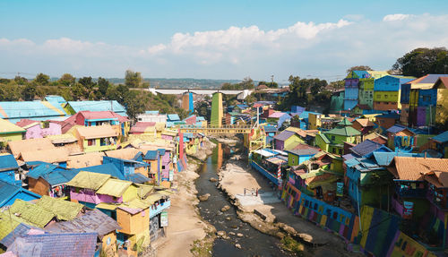 High angle view of city by sea against sky