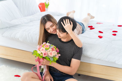 Midsection of woman sitting on bed