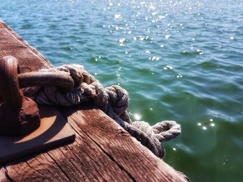 Close-up of rope on pier by sea