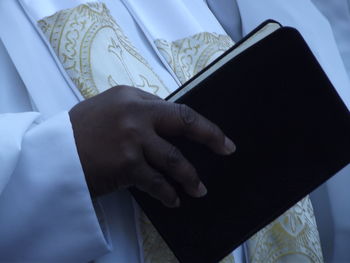 Close-up of priest holding bible