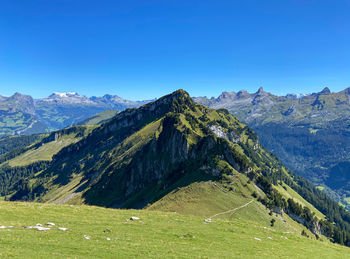 Scenic view of mountains against clear blue sky