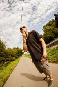 Man on road by trees against sky