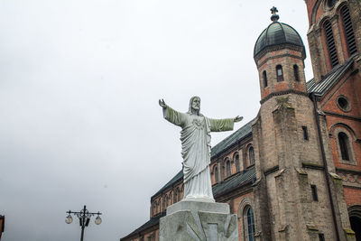 Low angle view of statue in city against sky