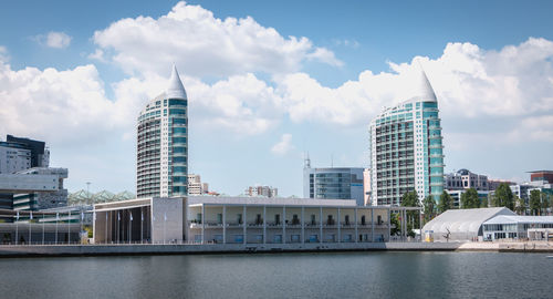 Modern buildings in city against cloudy sky