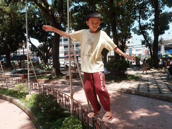 Happy boy standing on tree