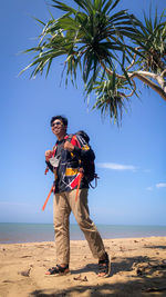 Man standing at beach against sky