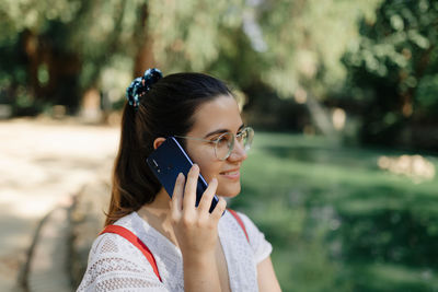 Portrait of young woman using mobile phone outdoors