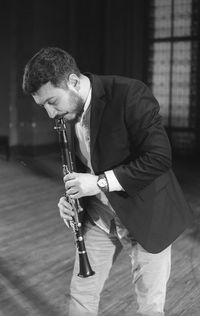 Man playing clarinet while standing at studio