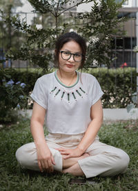 Portrait of smiling young woman sitting on plants