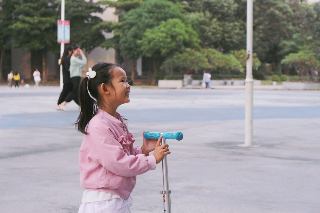 FULL LENGTH OF A GIRL HOLDING UMBRELLA ON STREET