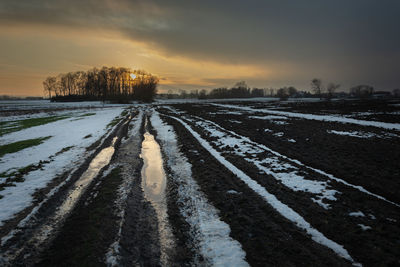 Snow covered land during sunset