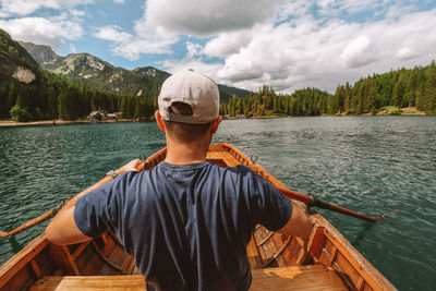 Rear view of man rowing on boat at lake 