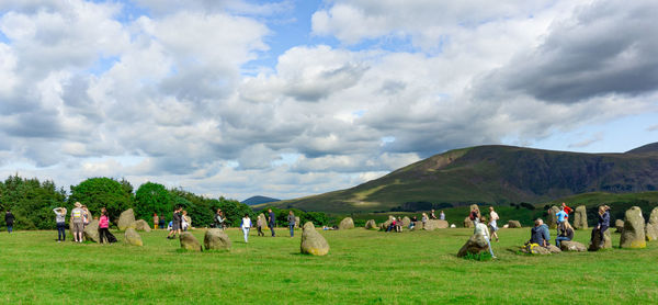 Group of people on field against sky