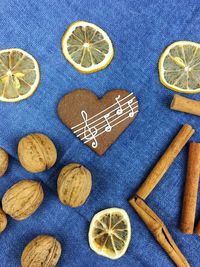 High angle view of gingerbread cookies with lemon and walnuts by cinnamon on table